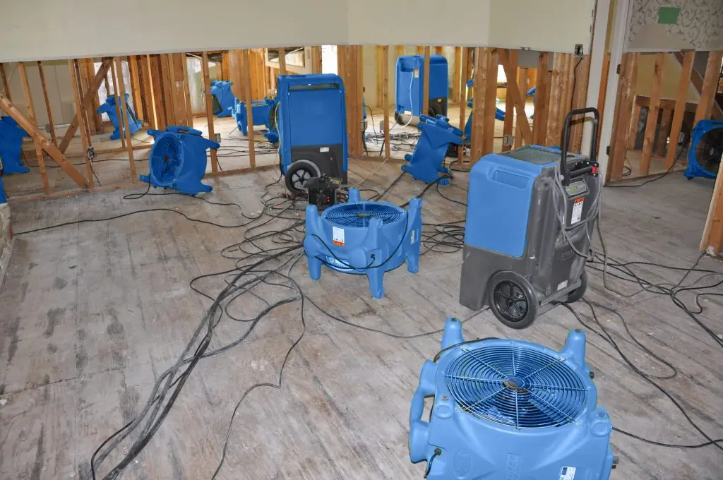 Air movers drying a gutted Burbank room after major water damage